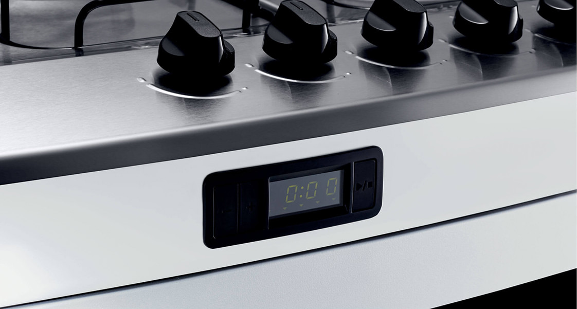 Para não esquecer de desligar as chamas das bocas ou do forno, você pode usar o timer digital. Ele fica na parte da frente do fogão, logo abaixo da mesa de inox. Basta colocar o tempo que você precisa e iniciar a contagem regressiva. Quando o tempo acabar, ele emite um alerta sonoro para te lembrar de conferir o prato. Muito bom, né?